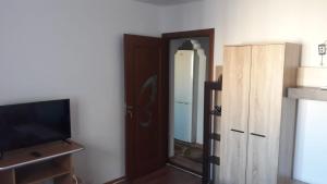 コンスタンツァにあるApartament Georgeのドア、テレビ、鏡付きの部屋