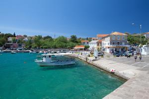 ein Boot im Wasser neben einem Dock in der Unterkunft Apartment Mira Šilo-Krk in Šilo