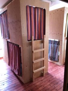 una cabina con tre finestre in una camera con pavimenti in legno di 尾道ゲストハウス シータ村 a Onomichi