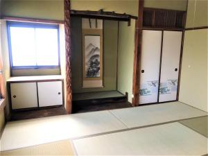 une chambre avec trois portes et une fenêtre dans l'établissement ゲストハウス三軒家, à Shirahama
