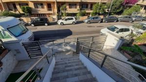 un grupo de escaleras con coches estacionados en un estacionamiento en ORISTANO CAMERA BLU max 2 pers, BAGNO E USO CUCINA, en Oristano