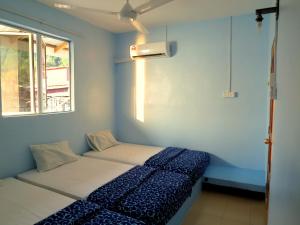 a blue room with a bed and a window at Pangkor Fish House in Pangkor