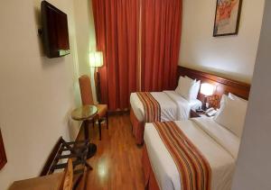 a hotel room with two beds and a television at Rotana Al Mesk Hotel in Medina