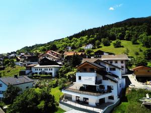 a village on a hill with houses and trees at Apart Alpengenuss in Ladis
