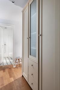 a white closet with a glass door in a bathroom at Beach Lux Apartment in Haifa