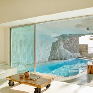 a living room with a swimming pool in a house at Cavo Tagoo Mykonos in Mýkonos City
