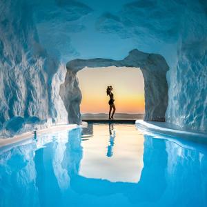 a woman standing inside of an ice cave in an ice at Cavo Tagoo Mykonos in Mikonos