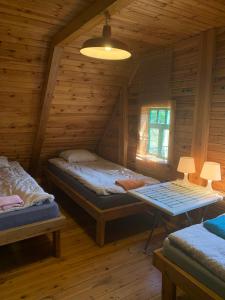 a bedroom with two beds in a log cabin at DOM NA GÓRCE in Narty