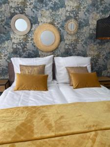 1 dormitorio con 1 cama con sábanas blancas y almohadas amarillas en Apartament BellaPola Loft en Nysa