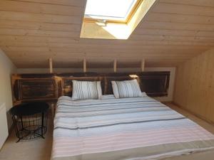 Schlafzimmer mit einem großen Bett und einem Dachfenster in der Unterkunft Pagojaus Apartamentai in Karališkiai