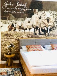 a bedroom with a bed and a painting of sheep at Hotel Pension Fortuna in Bad Bevensen