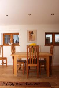 a dining room with a wooden table and chairs at Narnia in Wem