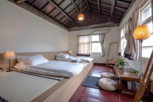 ein Schlafzimmer mit einem großen Bett und einem Tisch in der Unterkunft ZYIN Homestay in Kaohsiung