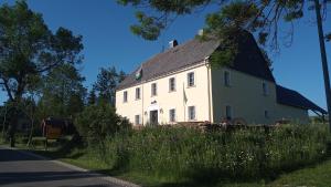 ein großes weißes Haus mit schwarzem Dach in der Unterkunft Gasthaus Ruebenau in Rübenau