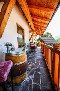 un patio al aire libre con una mesa de barril y sillas en Kia Ora Hotel Restaurant, en Wagrain