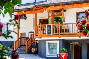 ein Haus mit einer Terrasse und einer Treppe darauf in der Unterkunft Kia Ora Hotel Restaurant in Wagrain