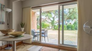 a living room with sliding glass doors leading to a patio at Sandy Shores - Sandbanks in Poole