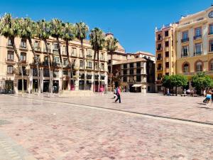 Un groupe de bâtiments dans une place où les gens marchent dans l'établissement Homely Málaga Luxury Atarazanas, à Malaga