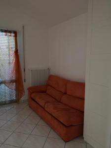 a brown couch in a living room with a window at Sul Confine in Cervia