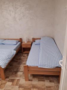 2 Einzelbetten in einem Zimmer mit gedankenlosem, gedankenlosem, gedankenlosem, gedankenlosem in der Unterkunft Apartmani Kosmac in Budva
