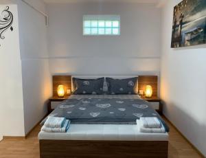 een slaapkamer met een groot bed met 2 nachtkastjes bij Vik. Apartment in Sighişoara