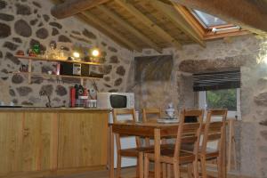 a kitchen with a table and chairs in a room at Penedino Mountain Cottage in Arcos de Valdevez