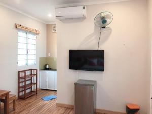 a living room with a flat screen tv and a fan at Tropical Garden Phu Quoc in Phu Quoc