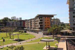 ダーウィンにあるWATERFRONT DARWIN TROPICAL GEMの建物が立ち並ぶ都市の中の公園