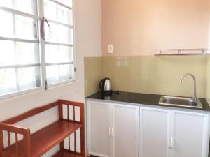 a kitchen with white cabinets and a sink and a table at Tropical Garden Phu Quoc in Phu Quoc