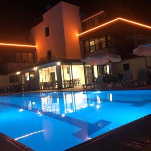 a swimming pool in front of a house at night at Oyster Boutique Hotel in Side