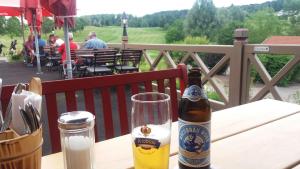 una botella de cerveza sentada en una mesa con un vaso en HOME4GOLF Uttlau, en Bad Griesbach