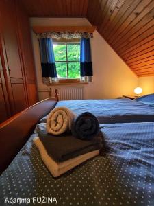 1 dormitorio con 1 cama con toallas en Apartment Cesar en Bohinj