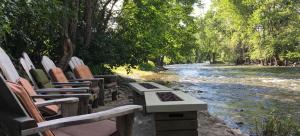 a group of chairs sitting next to a river at Twisp River Suites in Twisp