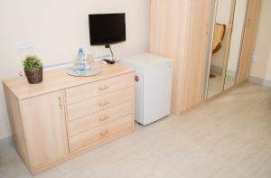 a room with a refrigerator and a television on a dresser at Casa Hortensia in Mangalia