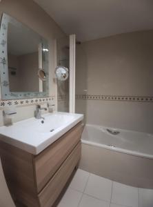 y baño con lavabo, bañera y espejo. en Apartamento Vive Jaca en Jaca