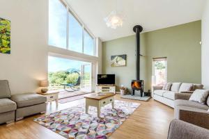 een woonkamer met een bank en een tafel bij Blackdown Views - New 6 Bedroom Eco House in Dunkeswell