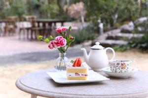 a table with a plate of cake and a cup of tea at Hotel Marital Sousei Kurume in Kurume