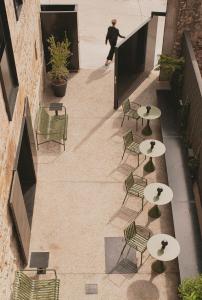 a woman walking down a sidewalk with tables and chairs at Casa Grande Hotel in Grañón