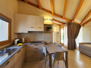 a kitchen and dining room with a table and chairs at Sirmione Rosselli Apartments in Sirmione