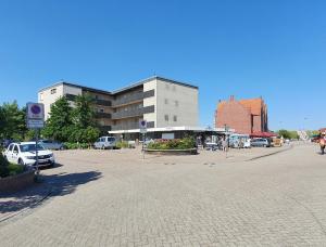 a parking lot in front of a large building at Ferienwohnung Strandjuwel am Strand in Norddeich