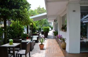 an outdoor patio with tables and chairs and plants at Hotel Gianlore in Milano Marittima