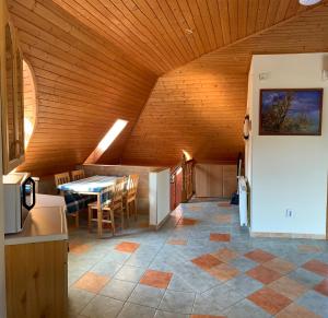 una cucina e una sala da pranzo con tavolo e soffitto in legno di House4U a Balatonszemes