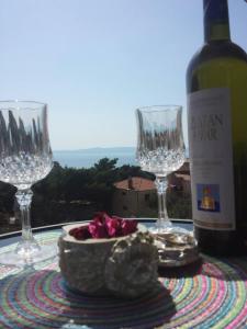 - une table avec des verres à vin et une bouteille de vin dans l'établissement Family Stakic, à Baška Voda