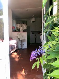 una sala de estar con flores púrpuras en la puerta en Adorable et amusante maison de campagne en La Croix-sur-Ourcq