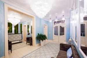 een grote kamer met blauwe muren en een kroonluchter bij Ferdinandhof Apart-Hotel in Karlsbad