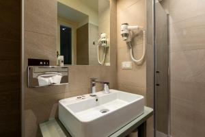 a bathroom with a white sink and a shower at Hotel Villa Cipressi, by R Collection Hotels in Varenna