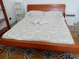 a bed with a wooden frame with two pillows on it at Guesthouse City Center in Bari