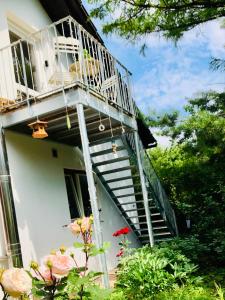 a white house with stairs and a balcony at Charmante Ferienwohnung mit Balkon im 5-Seen-Land in Hechendorf am Pilsensee