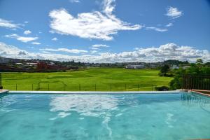 a swimming pool with a view of a green field at BG Tours in Ambohijanaka