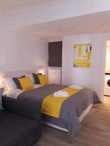 sypialnia z 2 łóżkami z żółtą i szarą pościelą w obiekcie Kolonaki Luxury backyard Studio w Atenach